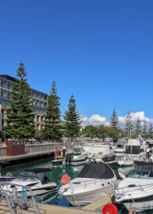 Waterfront apartment blocks overlooking Port Coogee Marina. Moored boats and yachts.