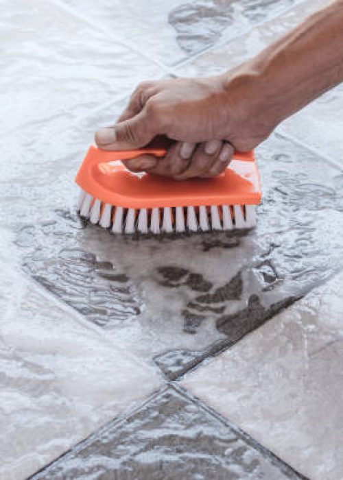 Men's hands are used to convert polishing cleaning on the tile floor.