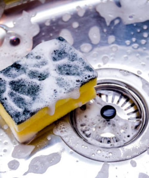 sponge in kitchen sink. Home cleaning concept.